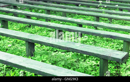 Antichi verde panche di legno a nuvoloso giorno di estate Foto Stock