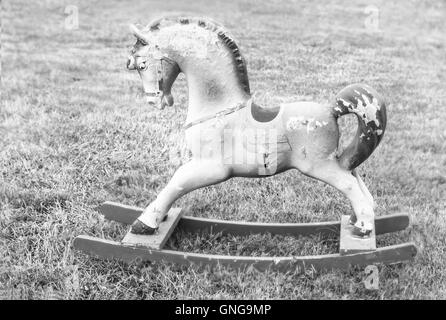 Bella vintage cavallo a dondolo sul prato estivo nei colori bianco e nero Foto Stock