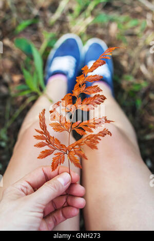 Close-up di donna holding autumn leaf, Bali, Indonesia Foto Stock