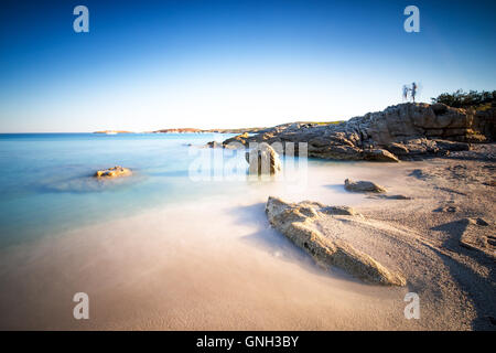 Silhouette di due persone in piedi su rocce alla spiaggia vicino Calvi, Corsica, Francia Foto Stock