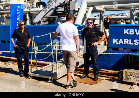 Karlskrona, Svezia - 27 agosto 2016: Coast Guard personale accogliente visitatore al pubblico aperto giorno di nave. Nave in background Foto Stock