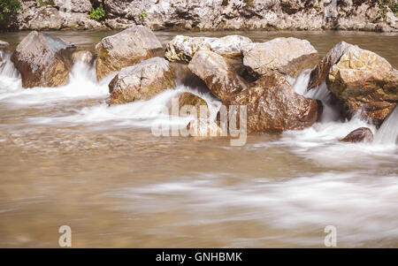 Il fiume che scorre attraverso le rocce lunga esposizione di White Water Rapids e onde lungo il tratto del fiume Gradac, Serbia Foto Stock