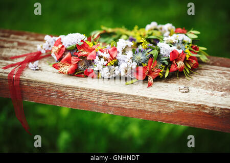 Composizione di fiori con gli anelli di nozze. Accessori di nozze. Foto Stock