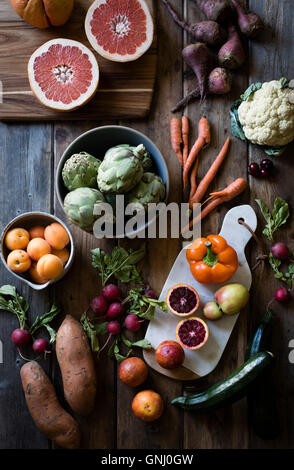 La frutta e la verdura di cui fuori su una tabella di fattoria. Carote, cavolfiori, barbabietole, pesche, arance. Foto Stock