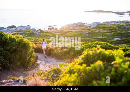 Giovane donna che corre lungo un sentiero, Corsica, Francia Foto Stock