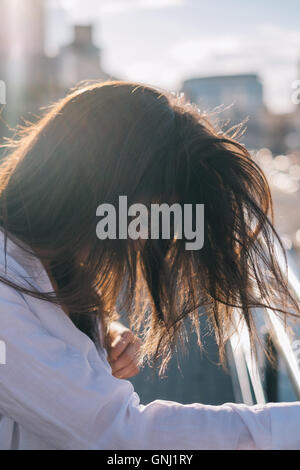 Ritratto di una donna con i capelli soffiando nel suo viso Foto Stock