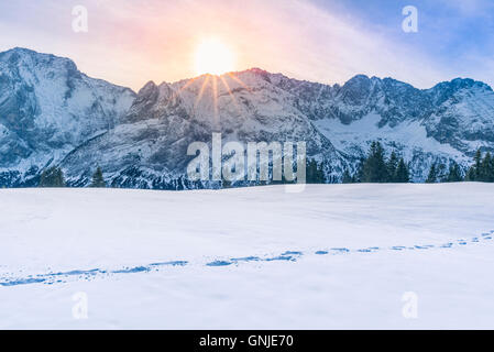 Sole che splende su picchi di montagna e neve Foto Stock