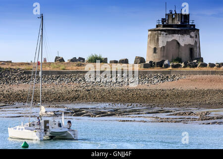 Un catamarano yacht passa un martello tower lasciando sovrano di Eastbourne Harbor estate Foto Stock