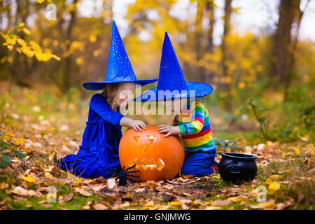 Bambini indossare blu costumi strega con cappelli giocando con zucca e ragno in autunno Park di Halloween. Kids dolcetto o scherzetto. Foto Stock