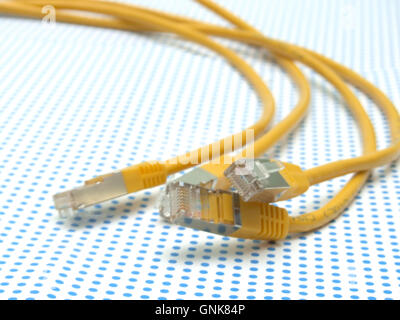 Cavo ethernet giallo su sfondo puntinato Foto Stock