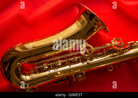 Il sassofono sulla delicata seta rossa Foto Stock