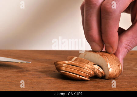 La trinciatura tenendo un fungo Foto Stock