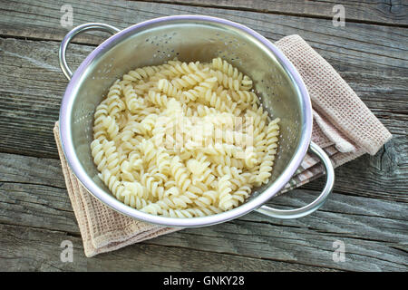 Carni cotte fusilli nel filtro sul tavolo Foto Stock