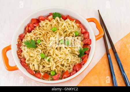 Preparate le tagliatelle con pomodoro e piselli in una ciotola Foto Stock