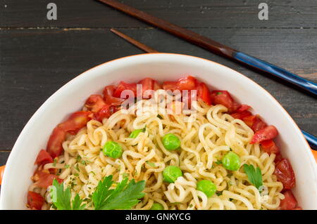 Preparate le tagliatelle con pomodoro e piselli in una ciotola Foto Stock