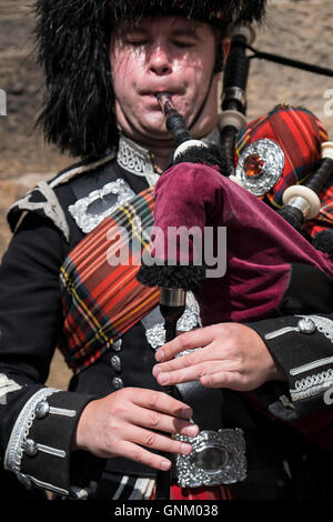Dettaglio dell'uomo la riproduzione di cornamuse per turisti indossando il tradizionale uniforme militare con tartan e kilt in Edimburgo, Scozia Foto Stock