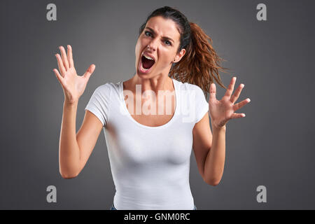 Una giovane e bella donna urlando furiosamente. Foto Stock