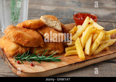 Pepite di pollo fritte sul bordo con salsa rossa Foto Stock