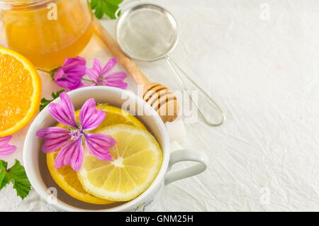 Malva Sylvestris, malva, tè con limone e fiori freschi Foto Stock