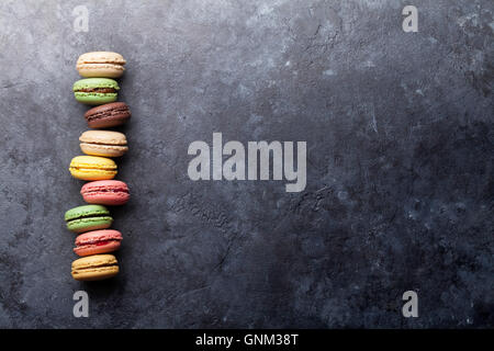 Amaretti colorati sul tavolo di pietra. Dolce macarons. Vista da sopra con copia spazio per il tuo testo. Foto Stock