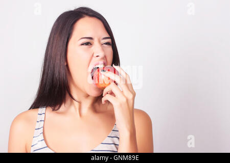 Giovane donna caucasica mangiando un apple. Fitness e il concetto di dieta. Uno stile di vita sano. Foto Stock