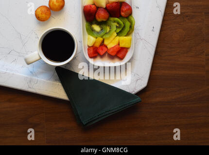 Muffin, frutta e la tazza di caffè su di un tavolo di legno. Una sana prima colazione. Salute e fitness concetto. Foto Stock