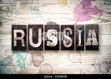 La parola " Russia " scritto in vendemmia, metallo sporchi tipo di stampa in rilievo su un dipinto di bianco sullo sfondo di legno con inchiostro e macchie di vernice. Foto Stock