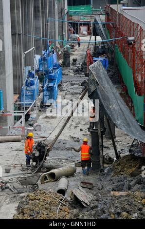 Lavoratori edili in cantiere con il blu di ponteggio e strumenti tra cui la pompa Bangkok in Thailandia Foto Stock