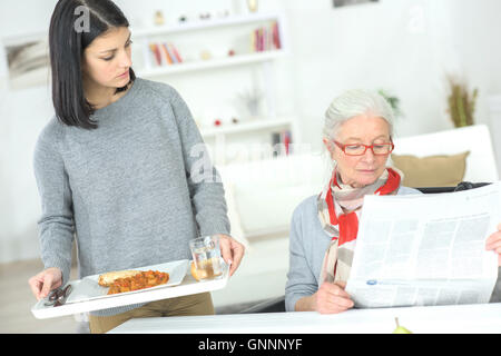 Accompagnatore che serve un senior lady Foto Stock