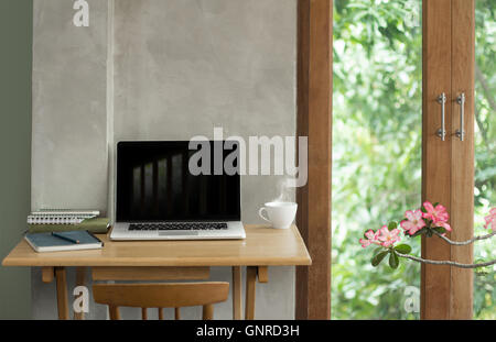 Notebook e laptop bevanda calda tazza sulla piccola scrivania Foto Stock