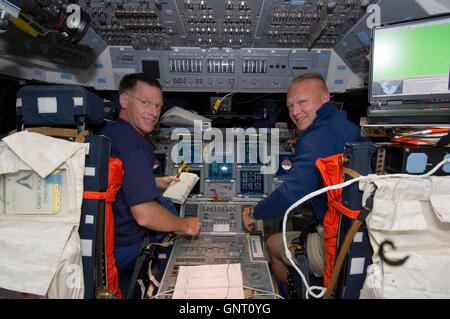 Space Shuttle Atlantis Commander Chris Ferguson e pilota Doug Hurley, destra, sorriso per la fotocamera dalle loro stazioni sulla Atlantis avanti ponte di volo durante la STS-135 missione giorno del volo due Luglio 9, 2011 in orbita intorno alla terra. Foto Stock