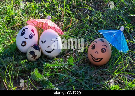 Uova divertente imitando i genitori bianco con versicolored baby e colorato amico maschio Foto Stock