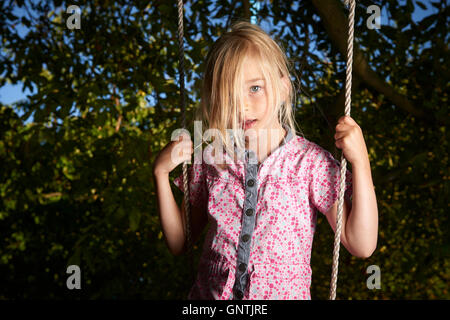 Bambino biondo ragazza triste permanente sulla rotazione. Foto Stock