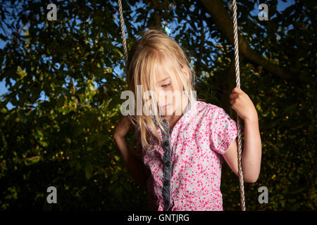 Bambino biondo ragazza triste permanente sulla rotazione. Foto Stock