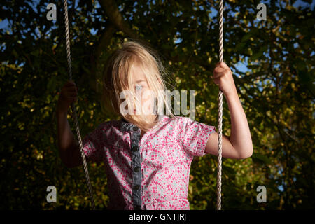 Bambino biondo ragazza triste permanente sulla rotazione. Foto Stock