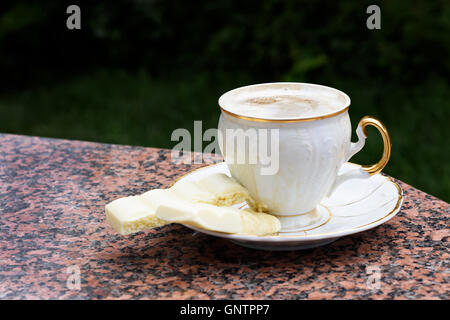 Uno bianco coppa piena di caffè espresso con crema marrone su porcellana  piattino con piccolo bricco per il latte sul vecchio vintage in legno di  bambù tabl Foto stock - Alamy