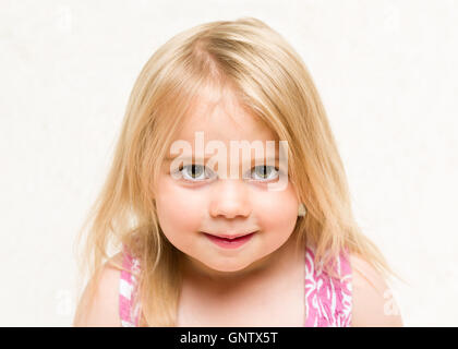 Closeup ritratto della bella bionda Bimbo bimba con cheeky grin Foto Stock