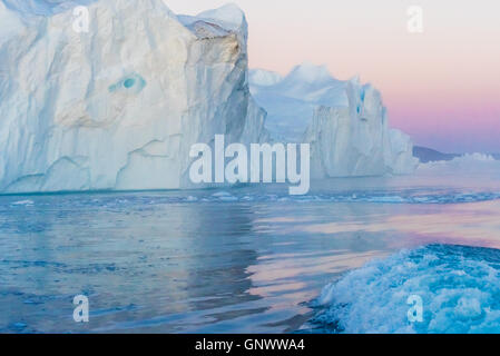 A filamento enormi iceberg in corrispondenza della bocca dell'Icejord vicino a Ilulissat a mezzanotte, la Groenlandia Foto Stock