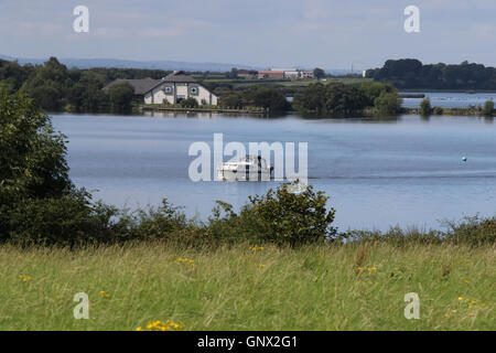 Barca nei pressi di Oxford isola sul Lough Neagh Irlanda del Nord con il.Oxford Isola Discovery Centre in background Foto Stock