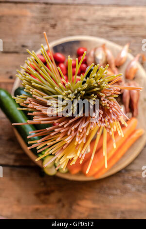 Italiano spaghetti colorati e verdure fresche come ingredienti tipici della sana cucina italiana Foto Stock