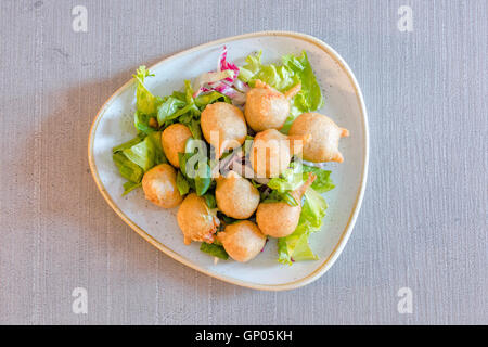 Una piastra di tipiche frittelle di farina di grano saraceno della Valtellina chiamato gli sciatt preparati con freschi ingredienti locali lombardia italia Foto Stock