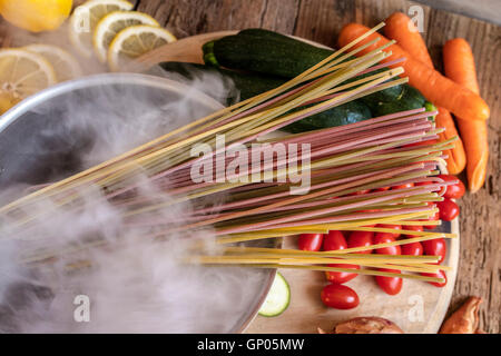 Italiano spaghetti colorati e verdure fresche come ingredienti tipici della sana cucina italiana Foto Stock