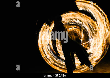 Un uomo che mostra fire dancing flaming sentieri. Foto Stock