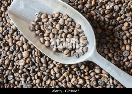 Tradizionali di chicchi di caffè tostati con la mano nel cestello con alluminio siviera. copia di spazio. Foto Stock