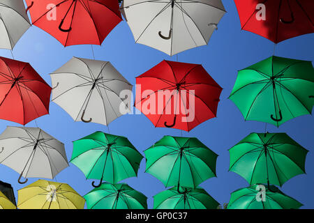 Ombrelli o ombrelloni contro un cielo blu chiaro con maniglie a gancio. Foto Stock