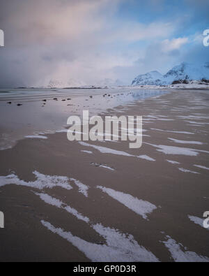 Patters di neve sulla sabbia in spiaggia Ytresand in inverno, Moskenesøy, Isole Lofoten in Norvegia Foto Stock