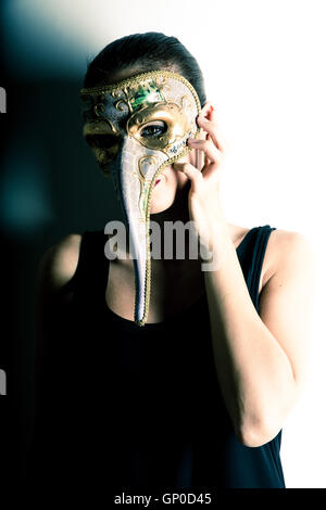 Un ritratto di una giovane donna adulta che indossa una maschera veneziana. Foto Stock