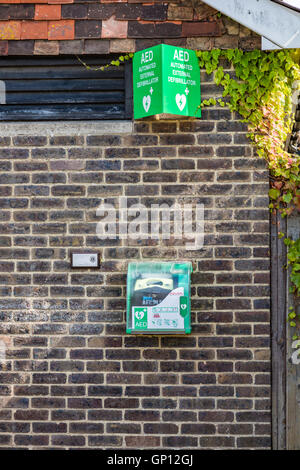 Una disponibilità pubblica di un defibrillatore automatico esterno su una parete igienica in Station Road, Tenterden, Kent, Regno Unito Foto Stock