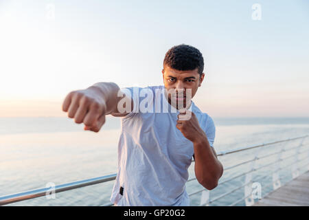 Focalizzato americano africano giovane atleta facendo formazione di inscatolamento al mattino Foto Stock