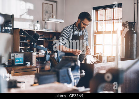 Creazione di un nuovo pezzo di gioielleria in officina Foto Stock